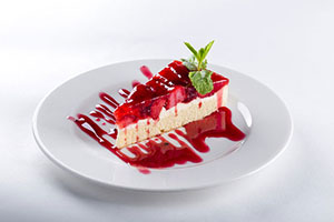 Strawberry Cheesecake on a plate with green garnish on top